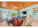 Cozy living room with wood ceiling, tile floors, comfortable seating, and bright natural light at 507 Spring Ave, Anna Maria, FL 34216