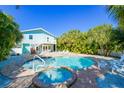Backyard featuring a refreshing pool and jacuzzi surrounded by lush tropical foliage at 507 Spring Ave, Anna Maria, FL 34216