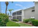 Charming condo featuring a screened lanai, well-maintained landscaping, and mature palm trees at 5681 Midnight Pass Rd # 104, Sarasota, FL 34242