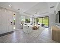 Bright living room with tile floors, a ceiling fan, and sliding glass doors to a green outdoor view at 6250 Grandview Hill Ct, Bradenton, FL 34203
