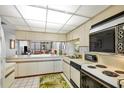 Classic kitchen with white cabinets, an oven, and a view to the living room and the balcony at 6480 Midnight Pass Rd # 311, Sarasota, FL 34242