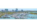 Aerial view of a marina filled with boats and yachts, with a city skyline in the backdrop at 688 Golden Gate Point # 701, Sarasota, FL 34236