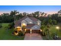 Stunning home with a three-car garage and a beautifully landscaped front yard at dusk at 6907 47Th E Ct, Ellenton, FL 34222