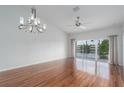 Spacious living room featuring hardwood floors, modern chandelier, and water views from the lanai at 7035 Scrub Jay Way # 202, Bradenton, FL 34203