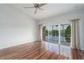 Main bedroom with hardwood floors, ceiling fan, neutral paint and water views from the lanai at 7035 Scrub Jay Way # 202, Bradenton, FL 34203
