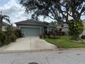 Charming single-story home with lush landscaping and a large shade tree in the front yard at 817 Tallgrass Ln, Bradenton, FL 34212