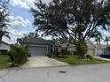 Charming single-story home with lush landscaping and a large shade tree in the front yard at 817 Tallgrass Ln, Bradenton, FL 34212