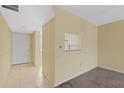 A bright open-plan living room area with neutral paint, carpet, and a passthrough to the kitchen at 860 Virginia St # 304, Dunedin, FL 34698