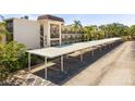 Exterior shot of covered parking with building and landscape in the background at 860 Virginia St # 304, Dunedin, FL 34698