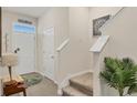 Welcoming foyer with stairs, tiled floors, and a decorative plant, creating a warm entry at 8628 Milestone Dr, Sarasota, FL 34238