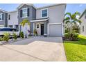 Two-story townhome features a gray facade, attached garage and well-maintained landscaping at 8628 Milestone Dr, Sarasota, FL 34238
