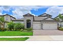 Beautiful single Gathering home features brick driveway, lush landscaping, and an attached two car garage at 8916 Isabella Cir, Parrish, FL 34219