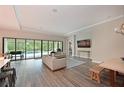 Open-concept living room has hardwood floors, neutral walls, crown moulding, and sliding doors at 8916 Isabella Cir, Parrish, FL 34219