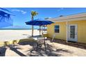 Outdoor patio area with brick pavers, seating, an umbrella, and a scenic beach backdrop at 105 Casey Key Rd # 20, Nokomis, FL 34275
