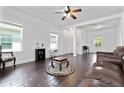 Bright living room with wood-look tile flooring, white walls, and a ceiling fan at 10926 Sand Pine Ln, Parrish, FL 34219