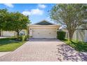 Charming single-Gathering home with a brick driveway, lush landscaping, and an attached two-car garage at 110 San Lorenzo Ct, Bradenton, FL 34208