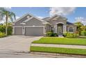 Stunning single-story home showcasing a two-car garage, lush green lawn, and impeccable landscaping at 11410 57Th E St, Parrish, FL 34219