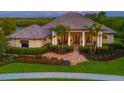 Stunning home featuring lush landscaping, paver walkway, and decorative stone accents at 11807 Rive Isle Run, Parrish, FL 34219