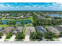 Aerial view of a residential home in a lakeside community with lush greenery and neighboring houses at 11811 Fennemore Way, Parrish, FL 34219
