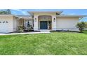 Inviting home featuring a lush green lawn, decorative landscaping, and a stylish front entrance with a striking front door at 1626 Ridgewood Ln, Sarasota, FL 34231