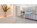 Bright living room with tile flooring, a decorative alcove, and views of the screened pool area at 1626 Ridgewood Ln, Sarasota, FL 34231