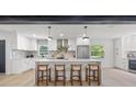 Modern kitchen featuring an island, stainless steel appliances, pendant lighting and white cabinetry at 1801 W Saint Isabel St, Tampa, FL 33607