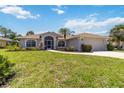 Inviting single-story home boasting a neatly kept lawn, mature landscaping, and an attached two-car garage at 251 Broadmoor Ln, Rotonda West, FL 33947