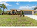 Beautiful single-story home with a well-manicured lawn, colorful plants and a two-car garage at 2801 Dalhart Ave, North Port, FL 34286