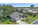 Aerial view of a well-maintained home with a spacious yard, mature trees, and a charming neighborhood setting at 3335 Meadow Run Ter, Venice, FL 34293