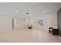 Bright living room featuring tile flooring, recessed lighting, and a large bay window providing ample natural light at 3335 Meadow Run Ter, Venice, FL 34293