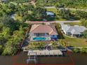 Aerial view of property, featuring a backyard pool, private dock, and waterfront access at 3620 Como St, Port Charlotte, FL 33948