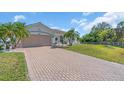 Well maintained residence featuring a tile roof and brick paved driveway leading to a two-car garage at 3620 Como St, Port Charlotte, FL 33948