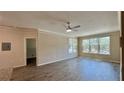 Bright living room featuring contemporary ceiling fan, crown molding, and luxury vinyl plank flooring at 4142 Central Sarasota Pkwy # 1423, Sarasota, FL 34238