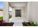 Inviting covered front porch with a modern dark brown door and updated landscaping at 4429 67Th E St, Bradenton, FL 34203