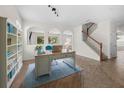 Bright home office featuring arched openings, a built-in bookshelf, and a staircase at 4429 67Th E St, Bradenton, FL 34203