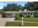 Charming single-story home featuring a well-manicured lawn, complemented by lush tropical landscaping in the front yard at 4695 86Th N Ave, Pinellas Park, FL 33782