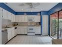 Bright kitchen with white cabinets, tile flooring, and modern appliances at 5039 Kestral Park Dr # 67, Sarasota, FL 34231