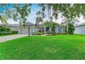 Charming single-story home featuring a manicured lawn and lush landscaping at 5386 Creekside Trl, Sarasota, FL 34243