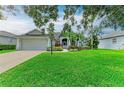 Charming single-story home featuring a manicured lawn and lush landscaping at 5386 Creekside Trl, Sarasota, FL 34243