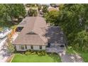 Aerial view of a well-maintained home with a large roof, green lawn, and mature trees in a suburban neighborhood at 5403 2Nd W Ave, Bradenton, FL 34209