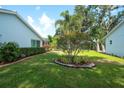 Well-maintained backyard featuring a lush lawn, mature landscaping, and manicured garden beds at 5812 Garden Lakes Fern, Bradenton, FL 34203