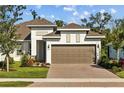Charming home featuring a two-car garage, brick paver driveway, and manicured landscaping at 5816 Mezzana Run, Palmetto, FL 34221