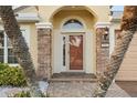 Up close front door with stone columns, house numbers, and mature landscaping at 5902 106Th E Ter, Parrish, FL 34219