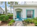 Inviting entryway with teal trim, a decorative door, and lush landscaping at 6546 Fairway Gardens Dr # 6546, Bradenton, FL 34203