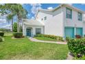Inviting home exterior featuring a well-manicured lawn and a teal door and window trim at 6546 Fairway Gardens Dr # 6546, Bradenton, FL 34203
