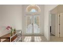 Bright foyer with tiled floors, double glass doors, and ample sunlight streaming through an arched window at 6721 Oak Manor Dr, Lakewood Ranch, FL 34202