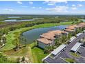 Stunning view of the condo's exterior with lake and golf course on display amidst well-manicured landscaping at 7005 River Hammock Dr # 203, Bradenton, FL 34212