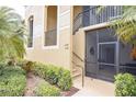 Exterior facade with stucco walls, stairs, and door with security screen at 7235 River Hammock Dr # 204, Bradenton, FL 34212