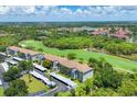 A scenic view shows well-maintained buildings next to a lush golf course and covered parking spaces at 8755 Olde Hickory Ave # 7105, Sarasota, FL 34238
