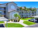 Well-maintained condo complex shows lush landscaping, covered parking, and multiple balconies at 8755 Olde Hickory Ave # 7105, Sarasota, FL 34238